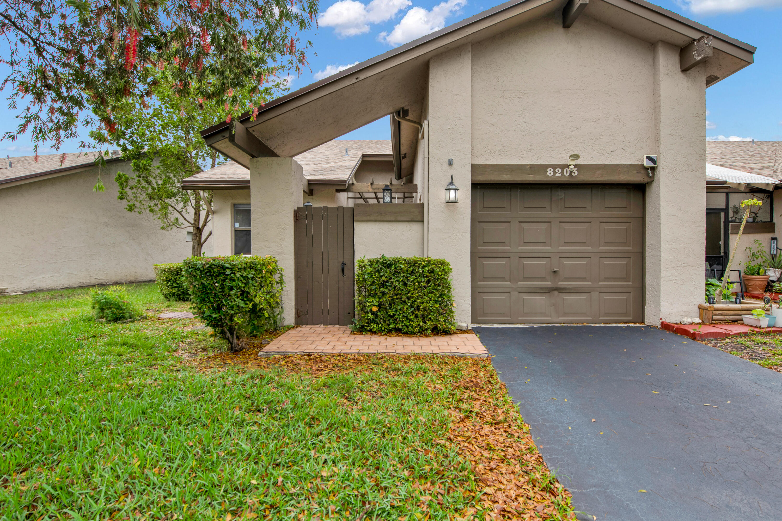 8203 Northwest 100th Way Tamarac, FL 33321 - Photo 2 of 31 a front view of a house with a yard