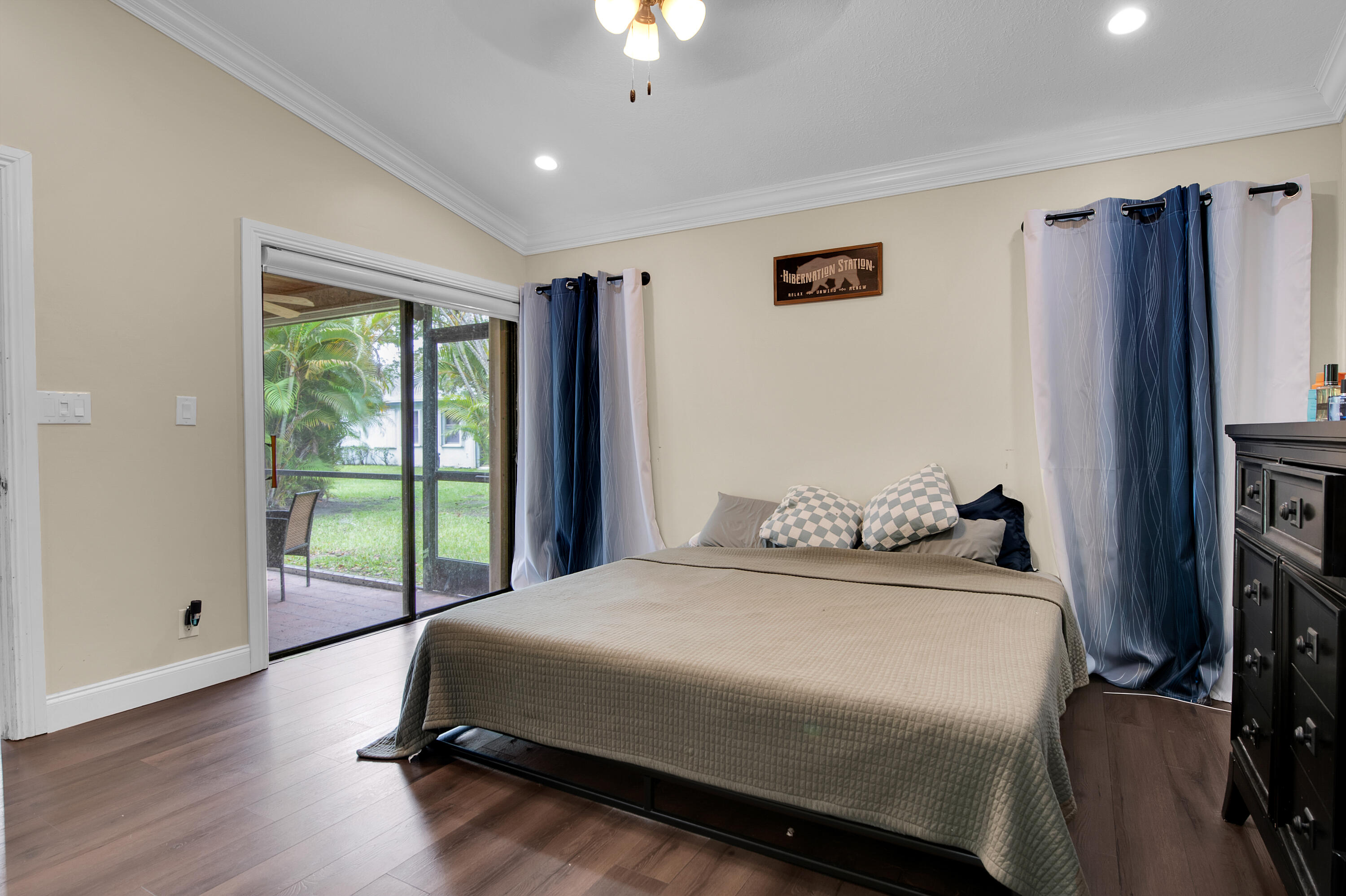 8203 Northwest 100th Way Tamarac, FL 33321 - Photo 27 of 31 a bedroom with a bed a flat screen tv and a large window with the outer view