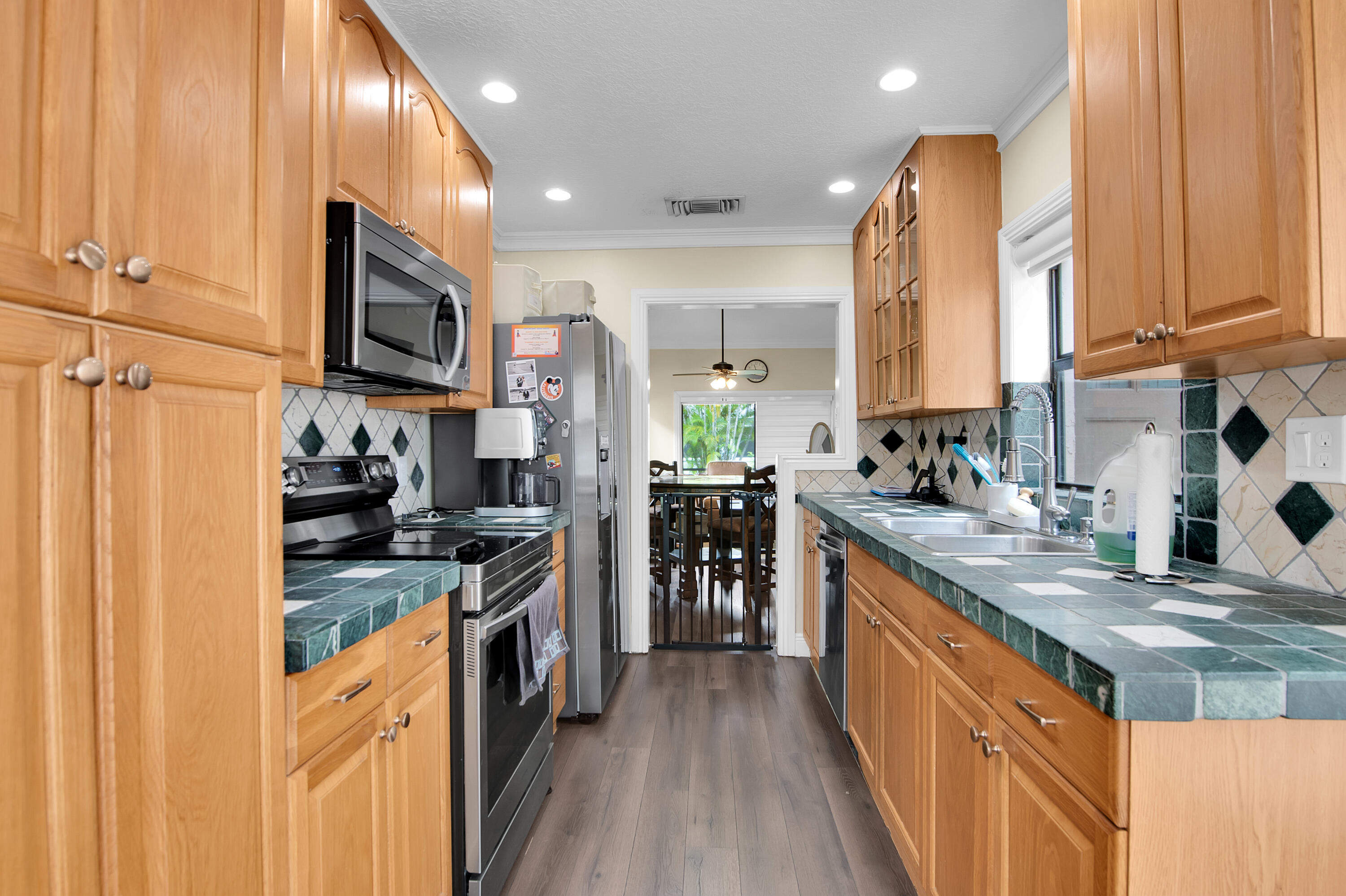 8203 Northwest 100th Way Tamarac, FL 33321 - Photo 9 of 31 a kitchen with stainless steel appliances granite countertop a stove a sink and a microwave