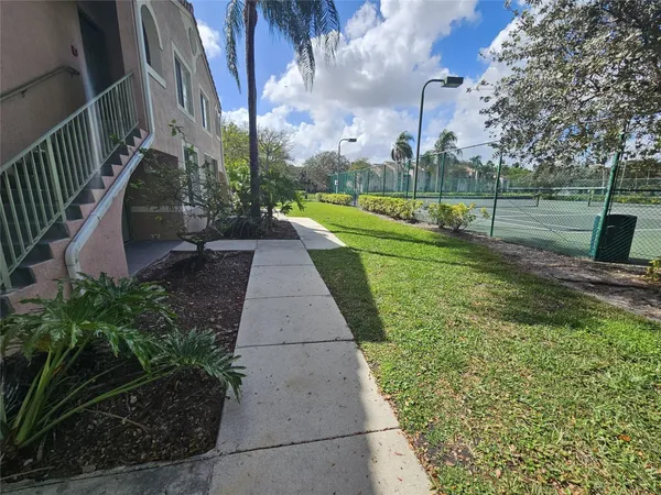 a view of a park with of a house in the background