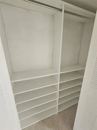 a view of walk in closet with empty racks