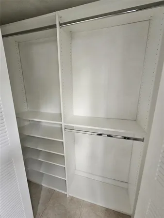 a view of walk in closet with empty racks