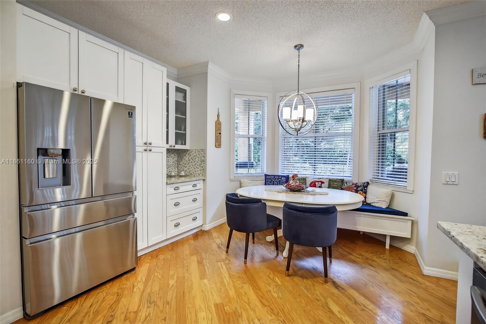 3989 Pinewood Lane Weston, FL 33331 - Photo 12 of 53 a kitchen with stainless steel appliances a dining table chairs stove refrigerator and cabinets