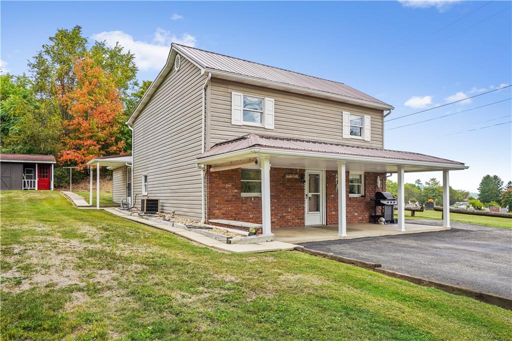 335 Spring Street Yukon, PA 15698 - Photo 3 of 24 A SIDE VIEW..CHECK OUT THE NICE FRON PORCH AND 1 OF THE 2 STORAGE SHEDS!