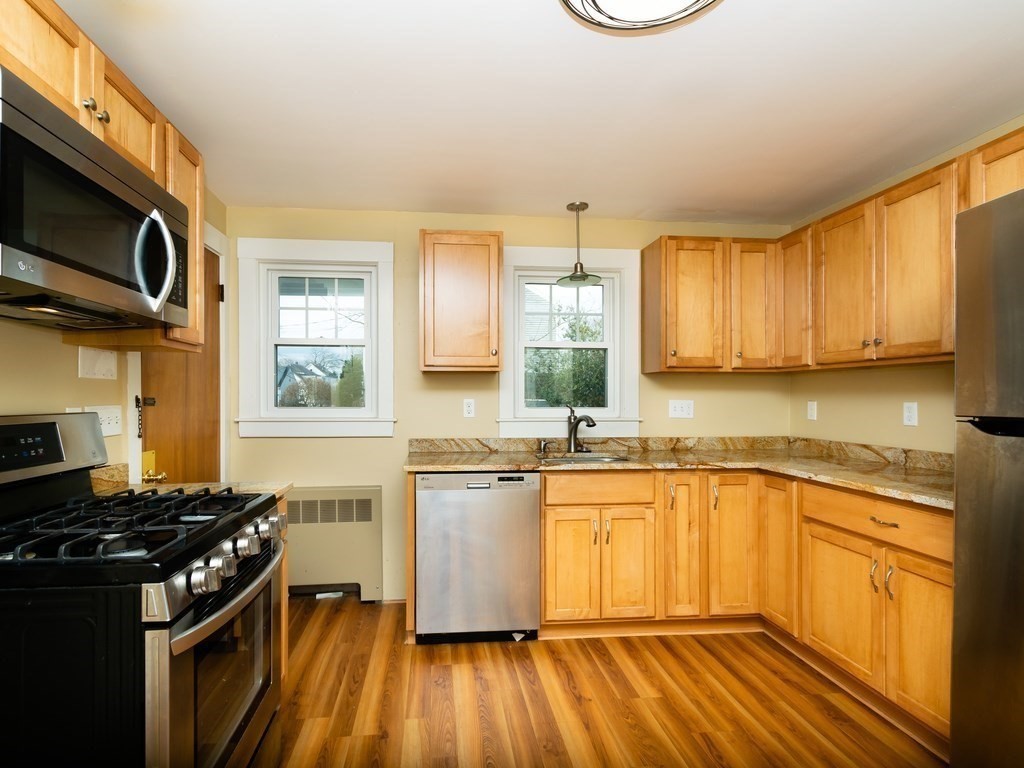 7 Mangano Court, Unit 2 Watertown, MA 02472 - Photo 2 of 14 a kitchen with stainless steel appliances a sink dishwasher stove and microwave