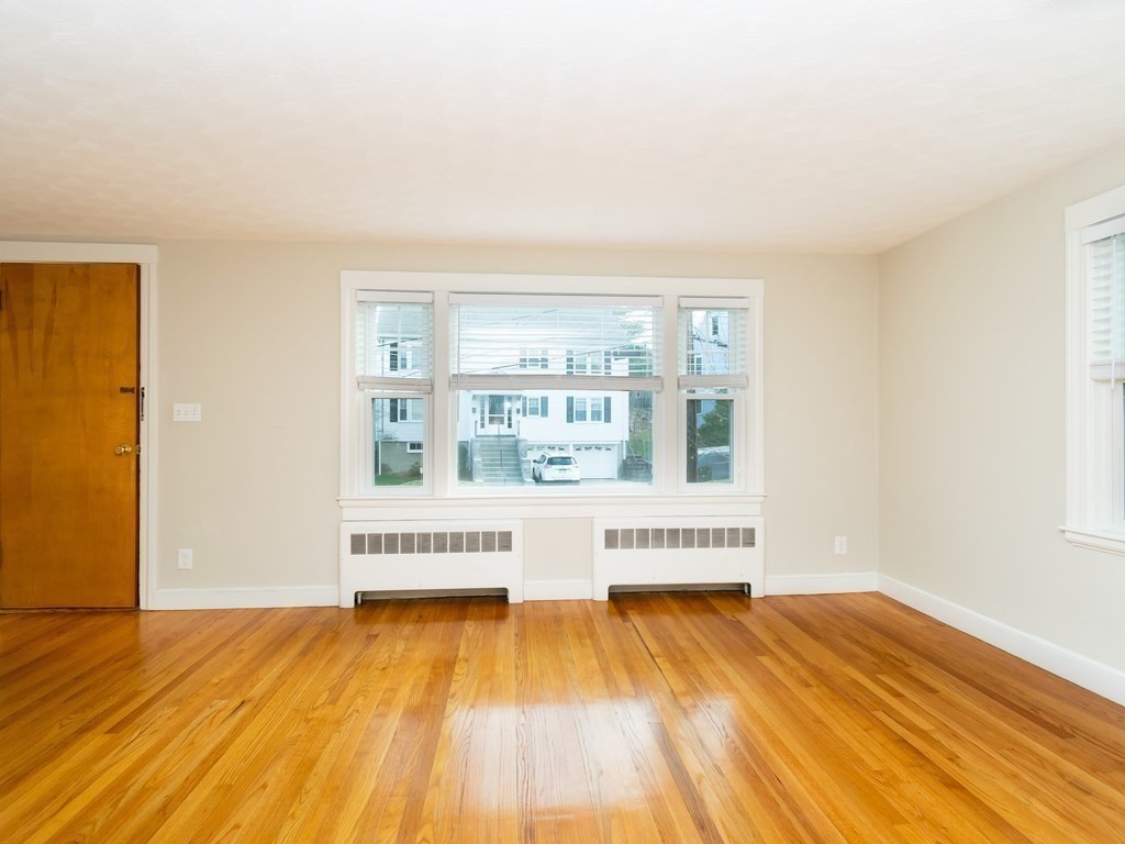 7 Mangano Court, Unit 2 Watertown, MA 02472 - Photo 6 of 14 a view of an empty room with window and wooden floor