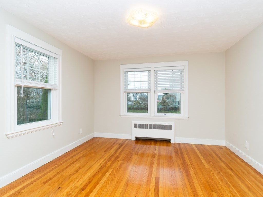7 Mangano Court, Unit 2 Watertown, MA 02472 - Photo 8 of 14 an empty room with wooden floor and windows