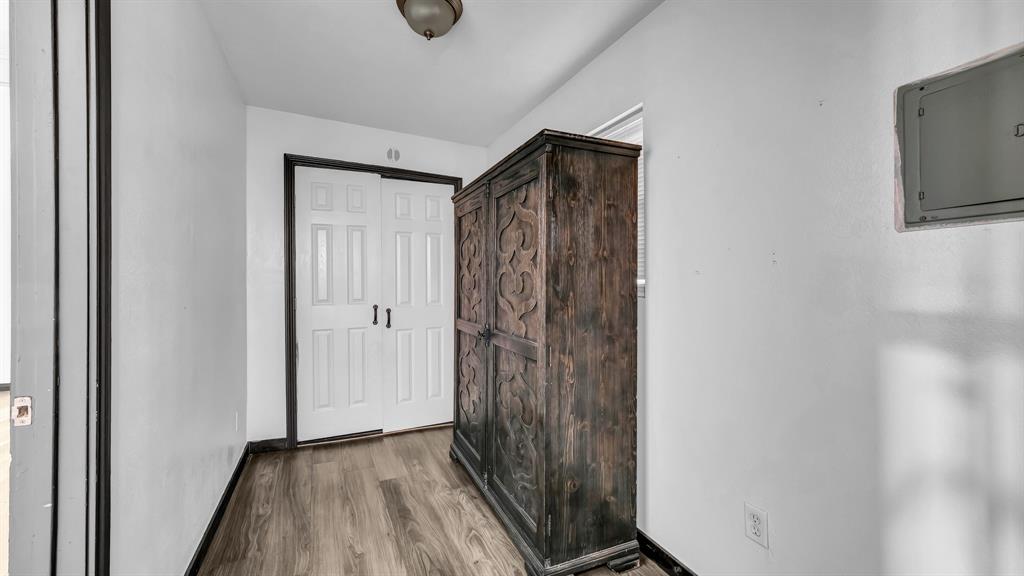 760 College Farm Road Stephenville, TX 76401 - Photo 13 of 32 a view of a hallway with wooden floor and a flat screen tv