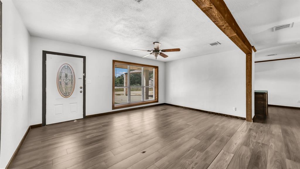 760 College Farm Road Stephenville, TX 76401 - Photo 2 of 32 a view of an empty room with wooden floor and a window