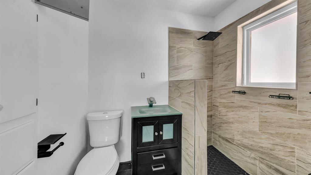 760 College Farm Road Stephenville, TX 76401 - Photo 23 of 32 a bathroom with a granite countertop toilet sink and shower