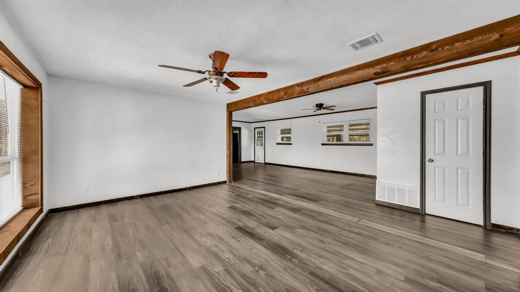 760 College Farm Road Stephenville, TX 76401 - Photo 3 of 32 a view of a big room with wooden floor and windows