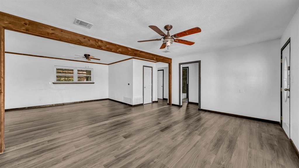 760 College Farm Road Stephenville, TX 76401 - Photo 4 of 32 a view of a hallway with wooden floor and a ceiling fan