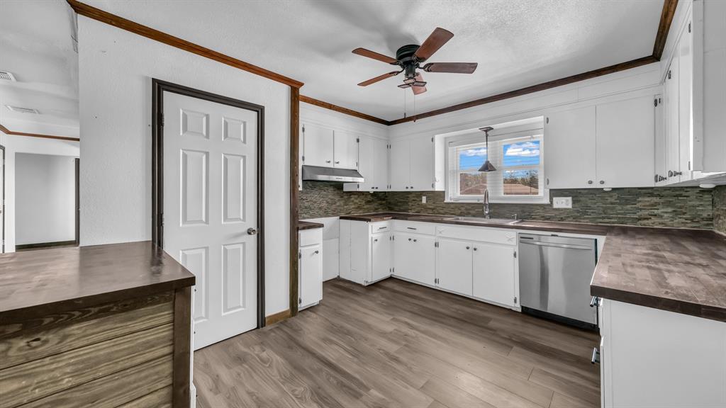 760 College Farm Road Stephenville, TX 76401 - Photo 10 of 32 a kitchen with granite countertop cabinets stainless steel appliances a sink and a wooden floor