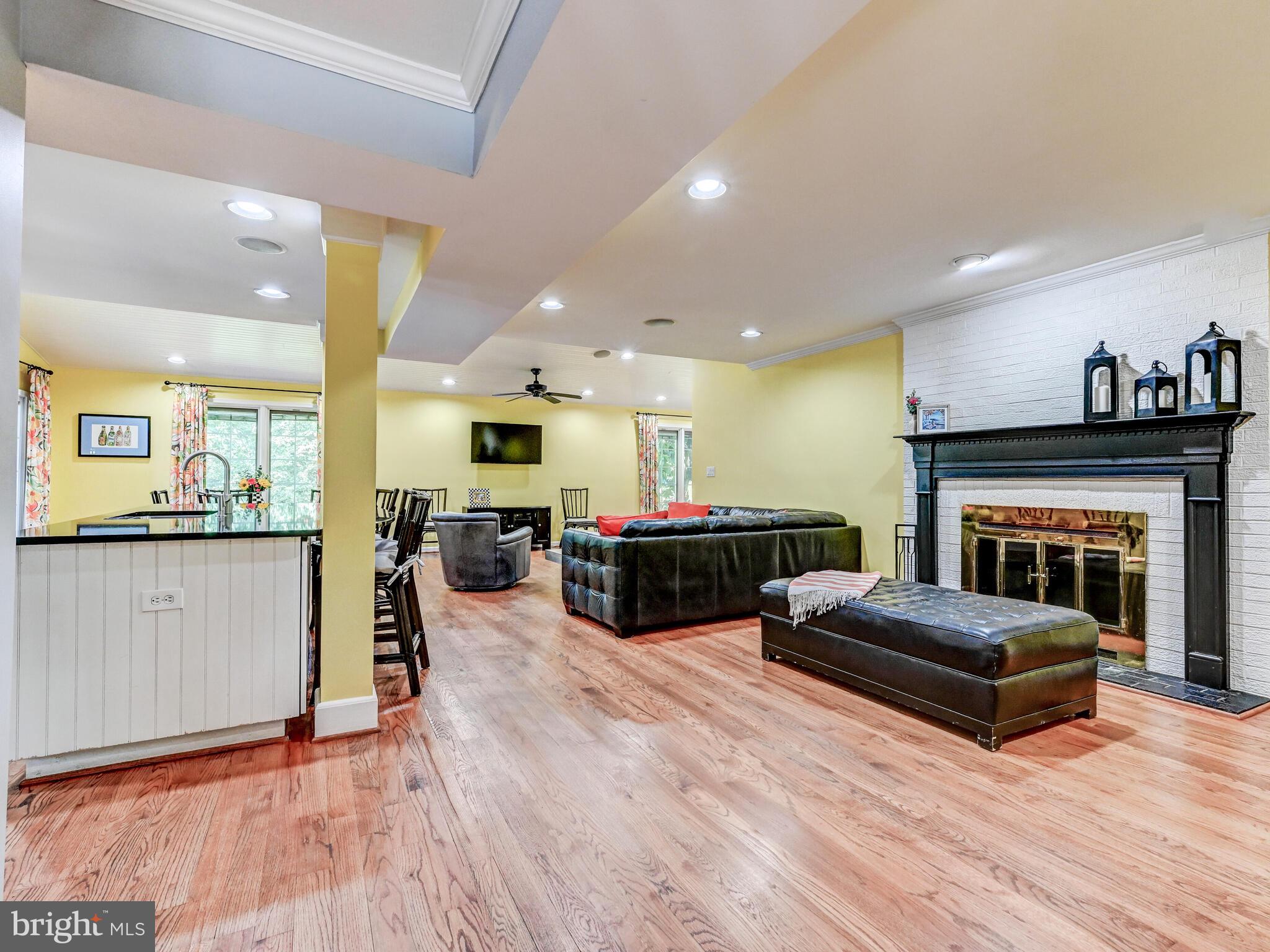 265 Hunters Ridge Road Lutherville-Timonium, MD 21093 - Photo 5 of 42 a living room with furniture a fireplace a flat screen tv and kitchen view