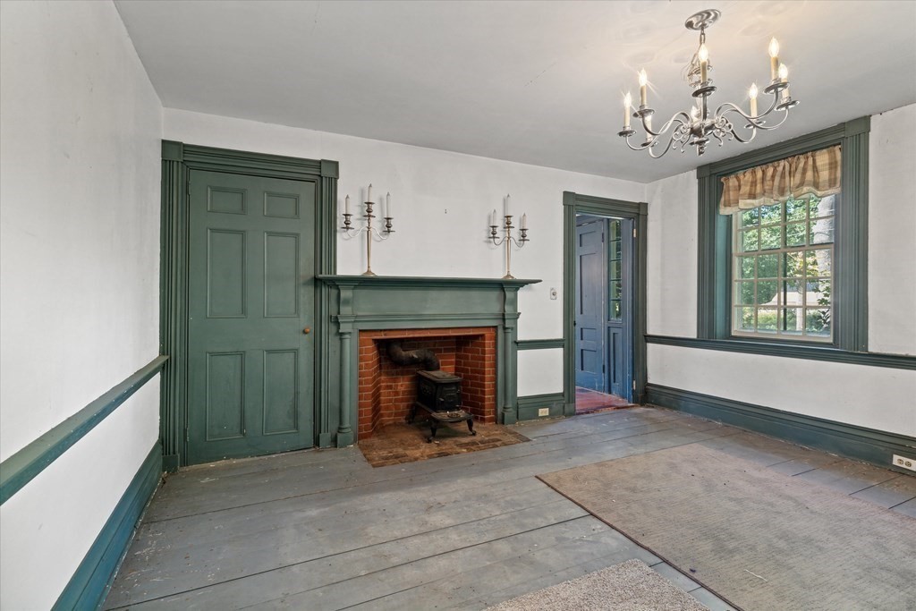 160 Hall Road Winchendon, MA 01475 - Photo 6 of 35 a view of a livingroom with a fireplace a chandelier and windows