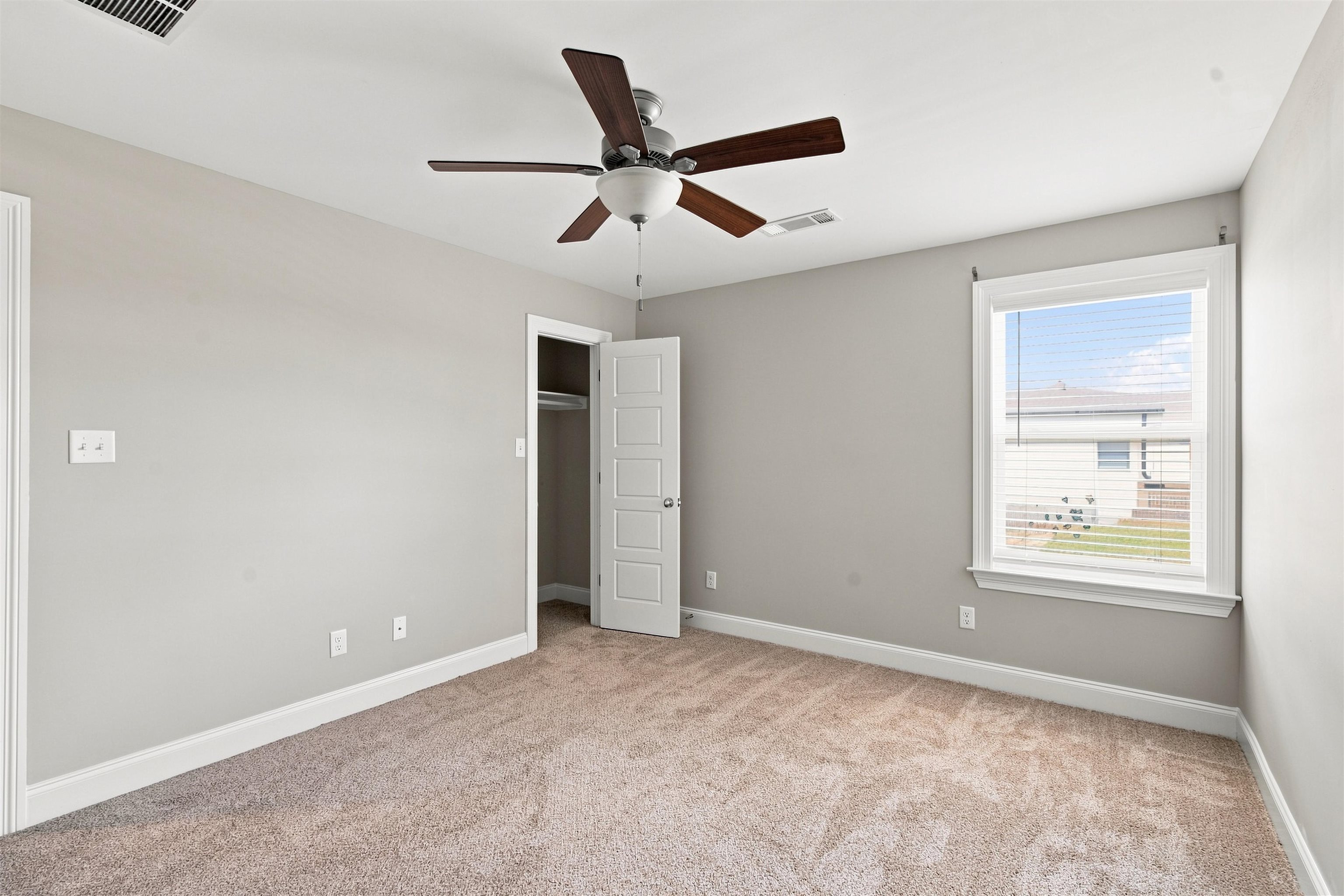 70 Trinity Cove Atoka, TN 38004 - Photo 11 of 19 Neutral wall paint, textured carpet, ceiling fan with integrated lighting, and window with blinds