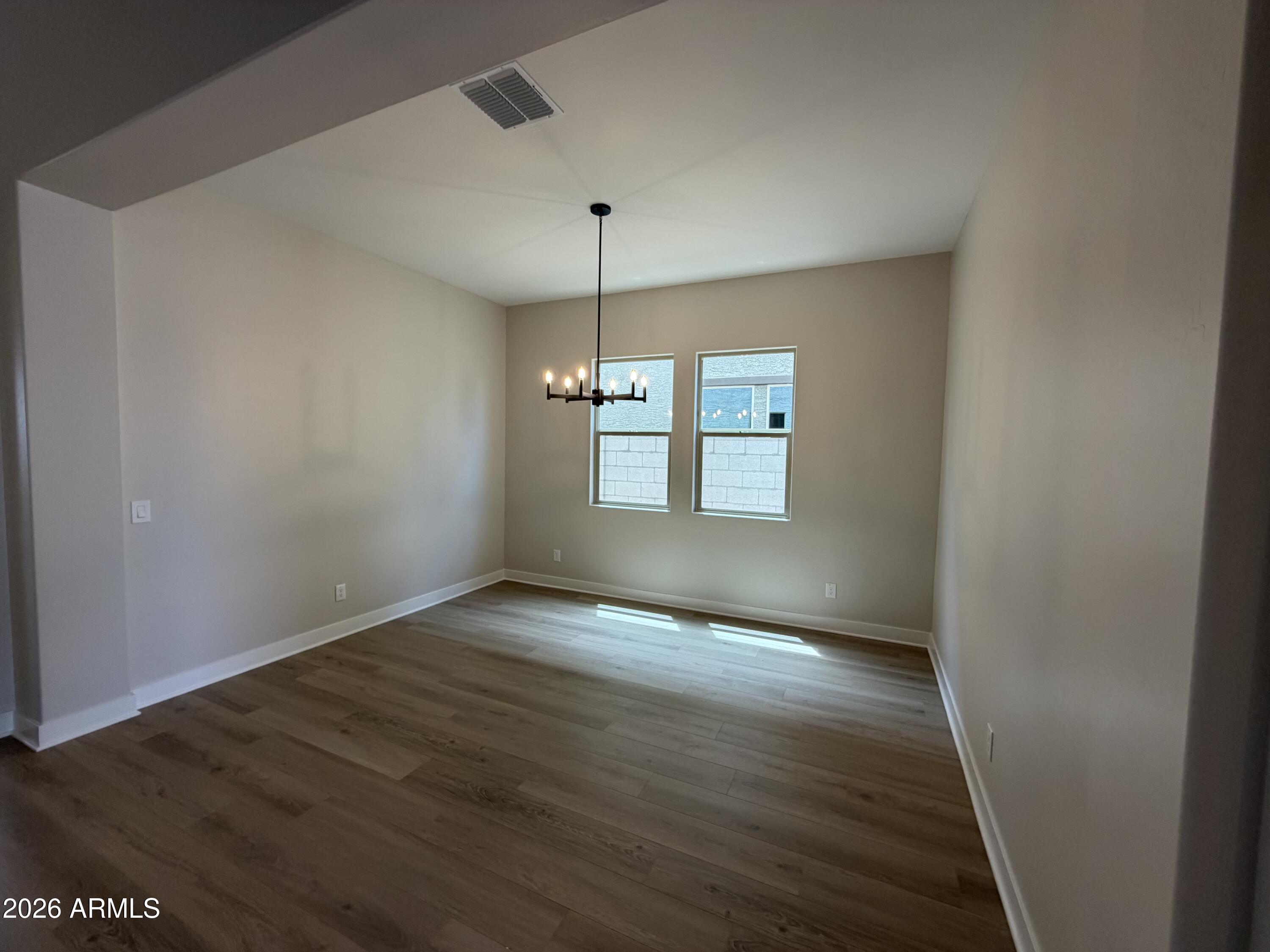 15767 West Sand Hills Road Surprise, AZ 85387 - Photo 7 of 60 an empty room with wooden floor and windows
