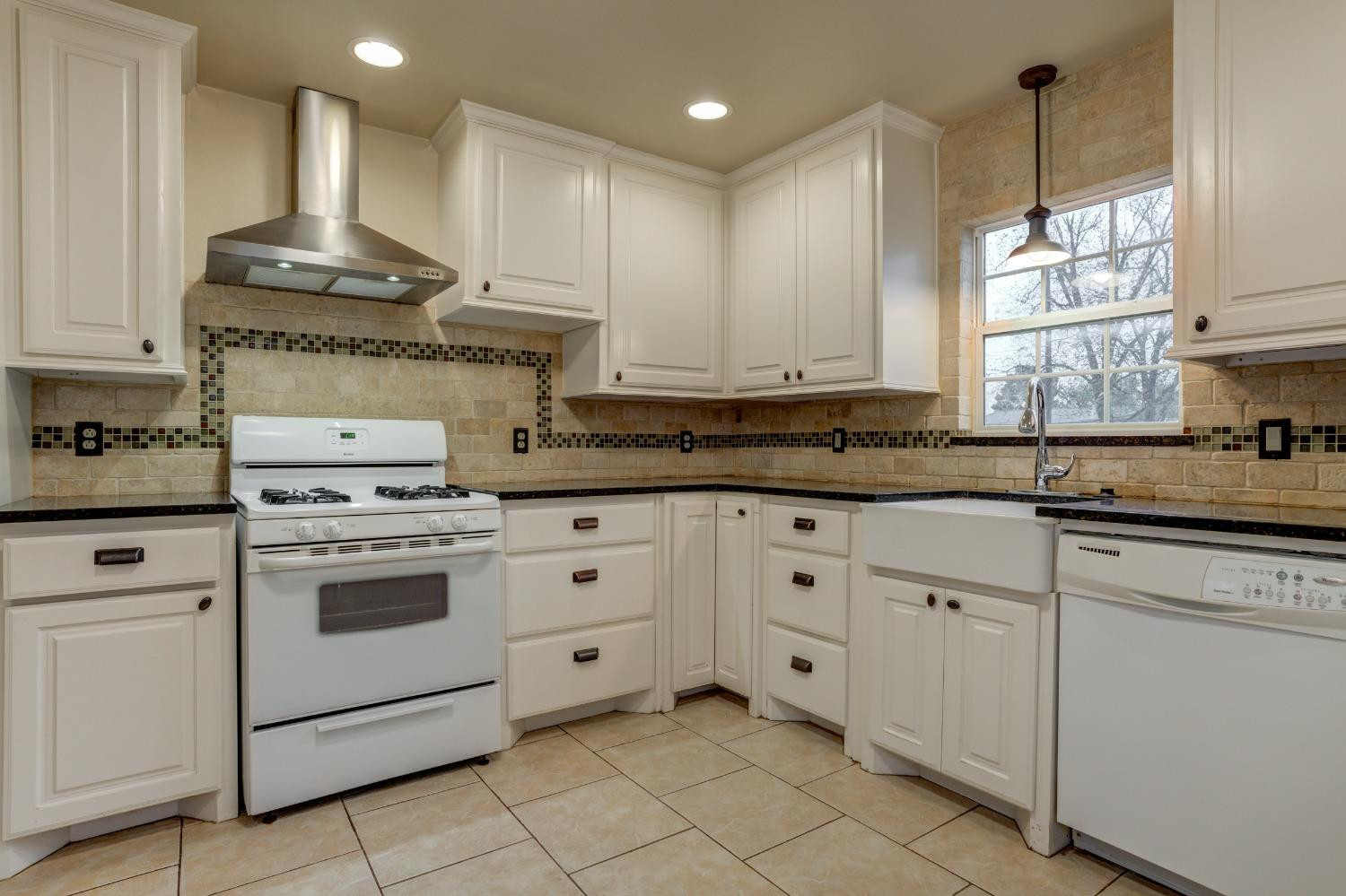 3415 27th Street Lubbock, TX 79410 - Photo 12 of 30 a kitchen with granite countertop white cabinets and white stainless steel appliances