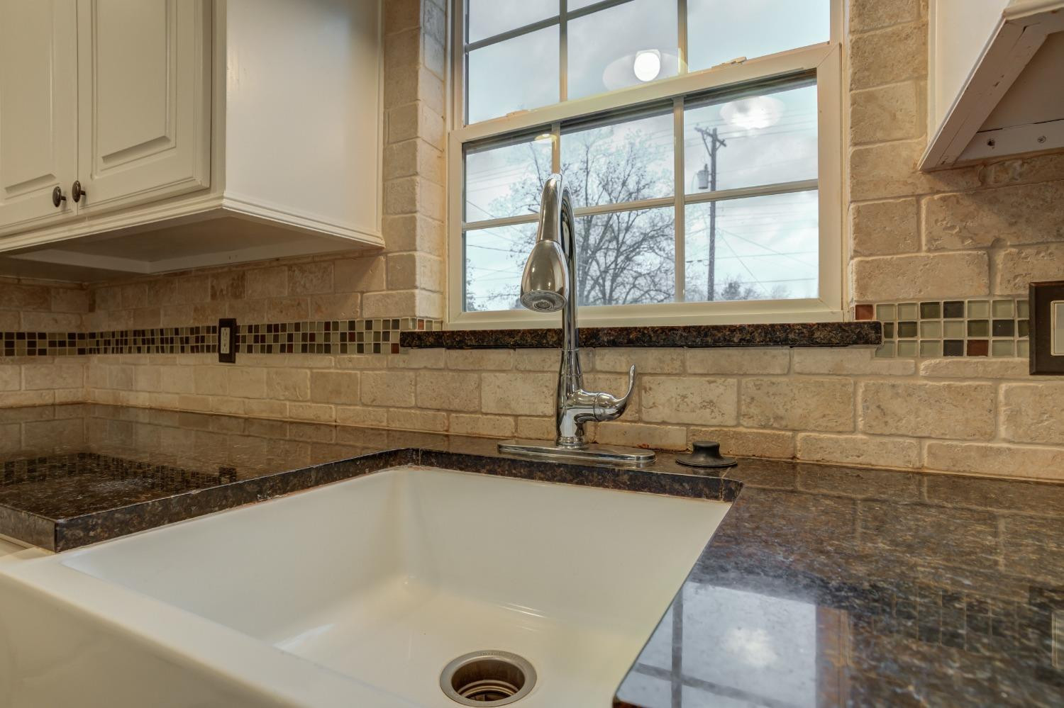 3415 27th Street Lubbock, TX 79410 - Photo 15 of 30 a bathroom with a granite countertop sink and a large window