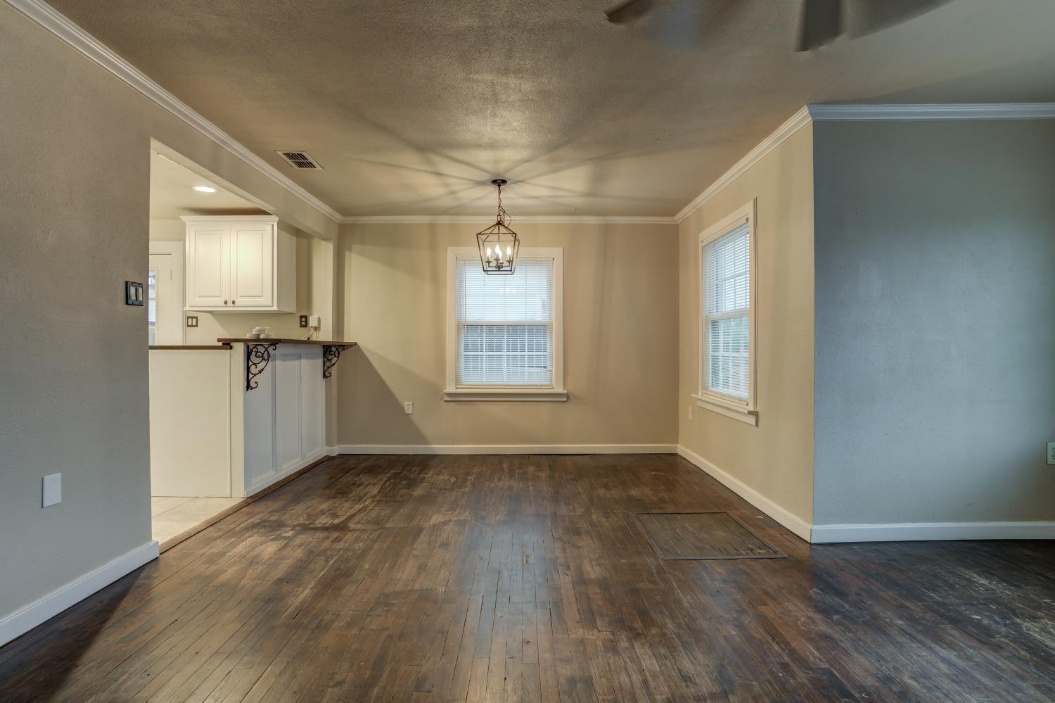 3415 27th Street Lubbock, TX 79410 - Photo 5 of 30 an empty room with wooden floor and windows