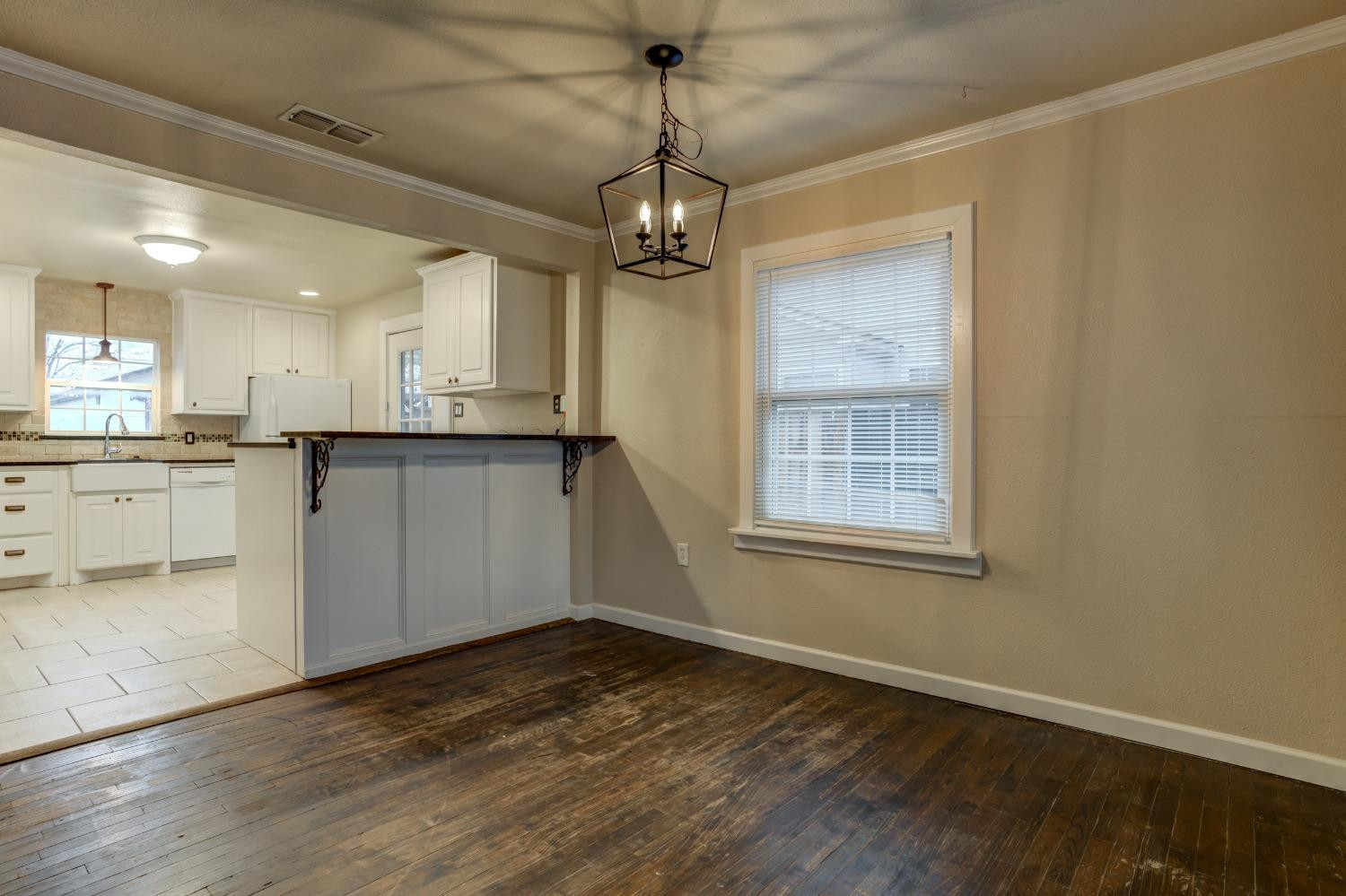3415 27th Street Lubbock, TX 79410 - Photo 9 of 30 a view of a kitchen with a sink cabinets and wooden floor