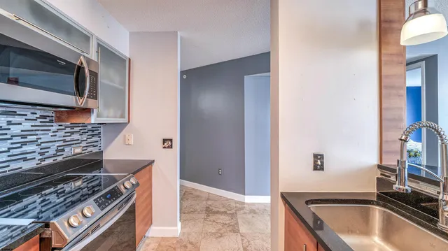 a kitchen with stainless steel appliances granite countertop a stove and a microwave