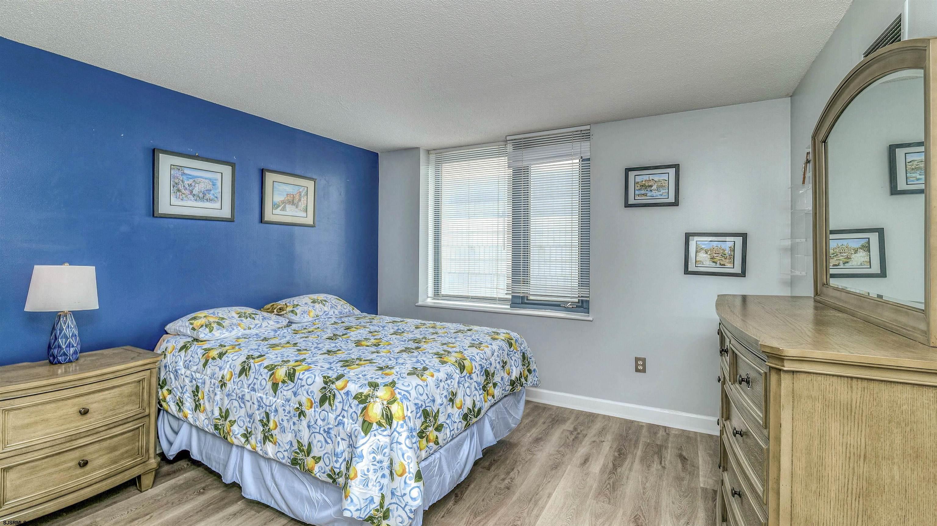 526 Pacific Avenue, Unit 903 Atlantic City, NJ 08401 - Photo 20 of 43 a bedroom with a bed and a dresser with wooden floor