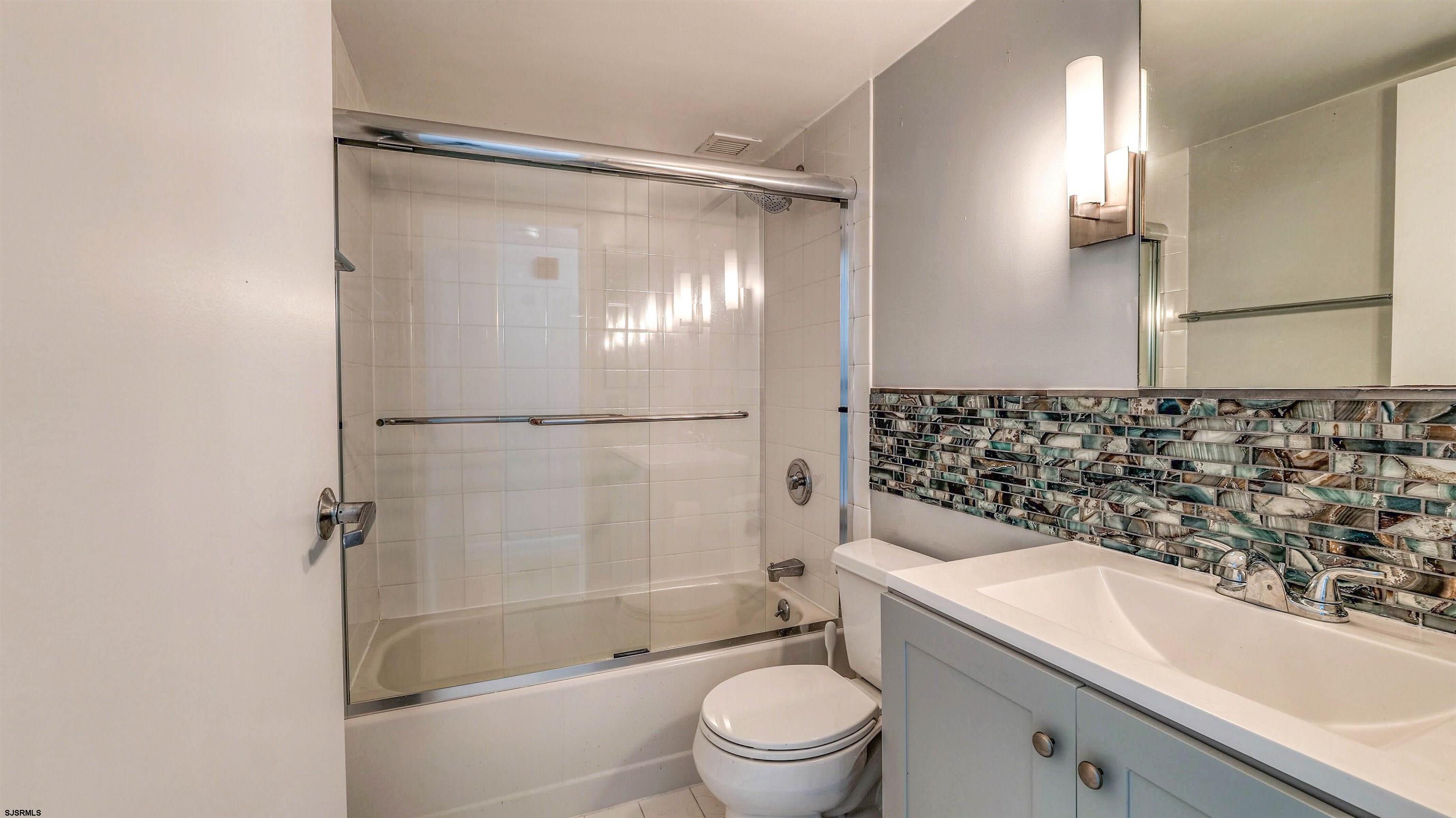 526 Pacific Avenue, Unit 903 Atlantic City, NJ 08401 - Photo 23 of 43 a bathroom with a granite countertop bathtub shower sink vanity and toilet