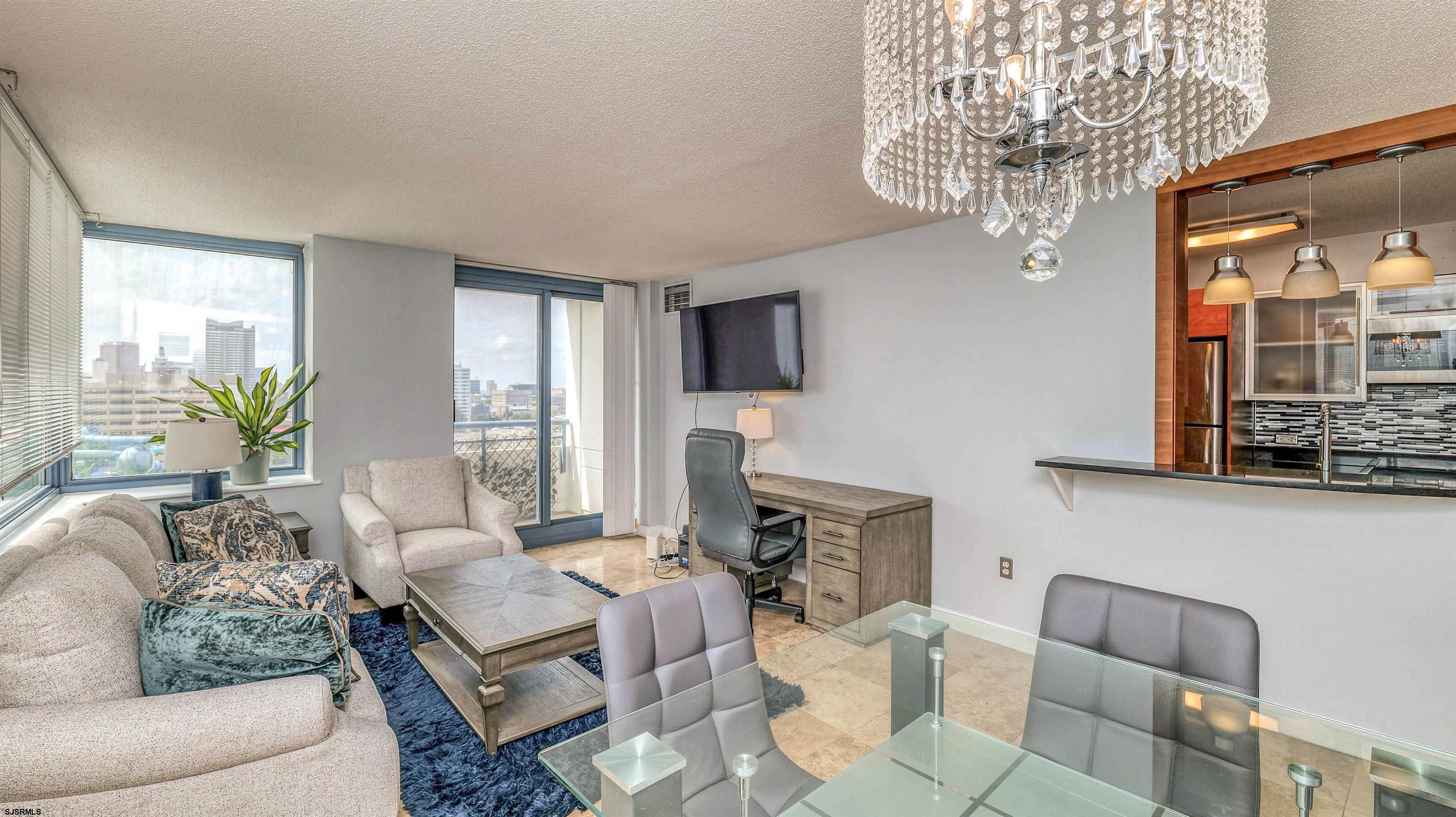 526 Pacific Avenue, Unit 903 Atlantic City, NJ 08401 - Photo 8 of 43 a living room with furniture a chandelier and a flat screen tv