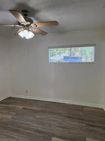 a view of wooden floor and a chandelier fan in a room