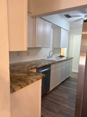 a kitchen with stainless steel appliances granite countertop a sink a stove and a refrigerator