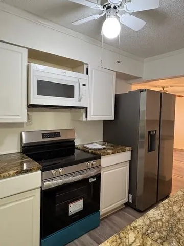a kitchen with stainless steel appliances granite countertop a stove and a refrigerator