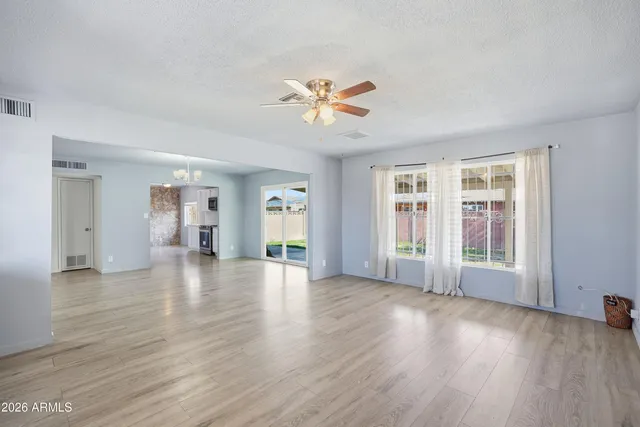 a view of an empty room with window and wooden floor