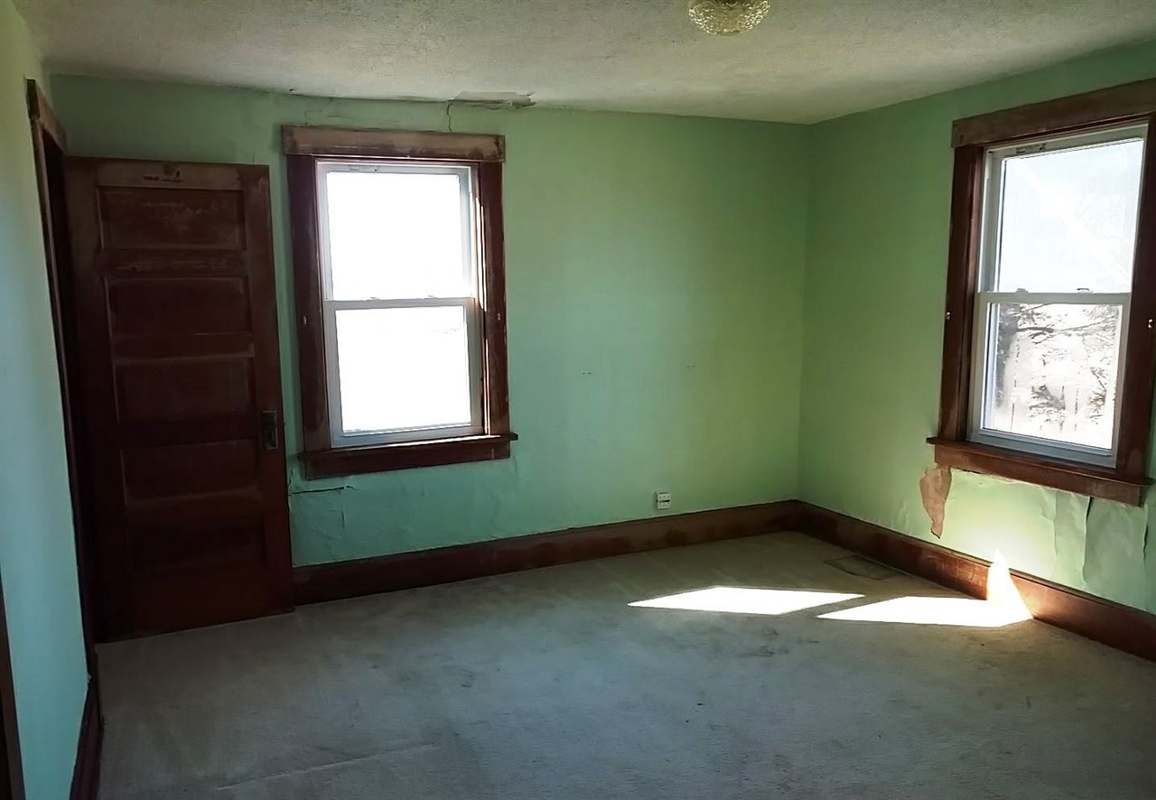 4287 South Freeport Road Polo, IL 61064 - Photo 8 of 11 an empty room with a window and a fireplace