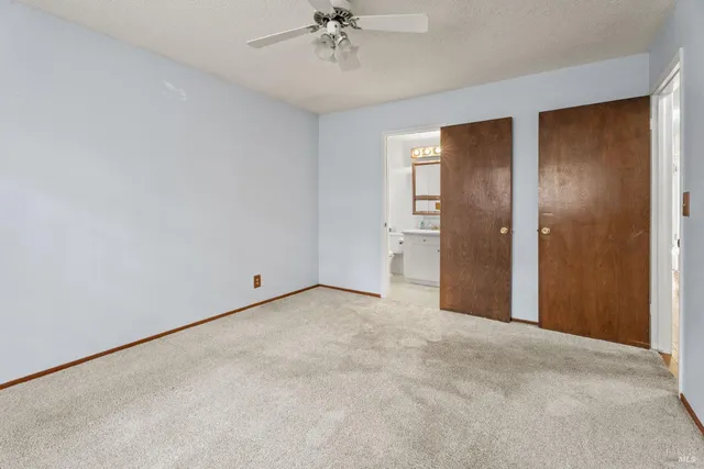 a view of an empty room with a ceiling fan