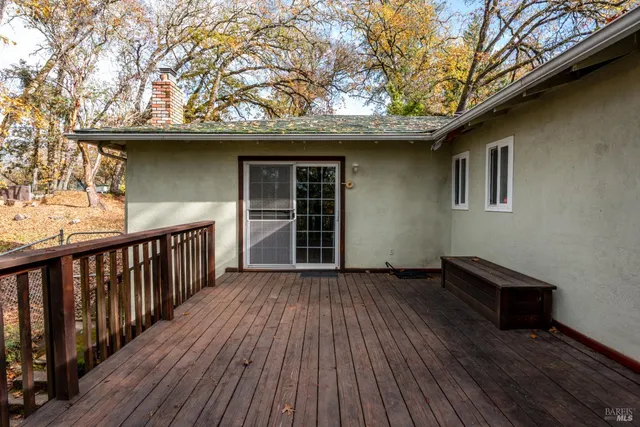 a view of backyard with wooden floor and fence