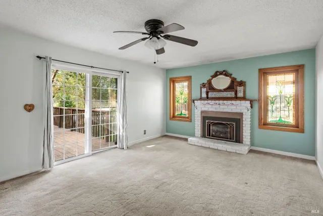 a view of an empty room with a fireplace and a window