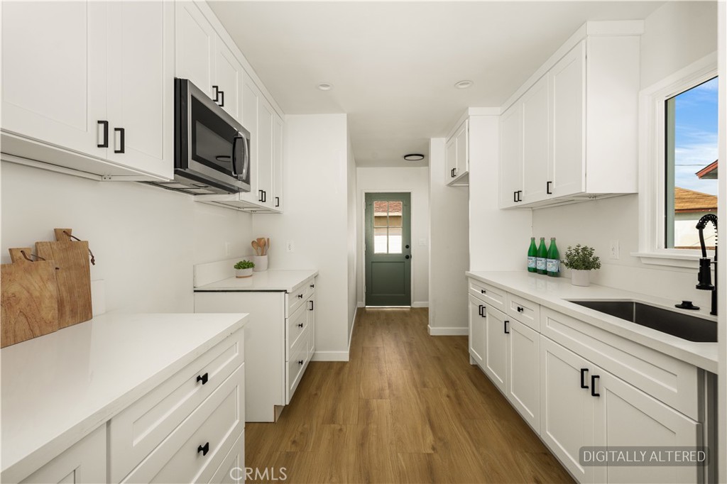 1013 West 138th Street Compton, CA 90222 - Photo 14 of 30 a kitchen with white cabinets stainless steel appliances and sink