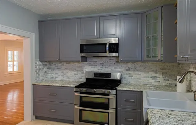 a kitchen with granite countertop a stove and a microwave