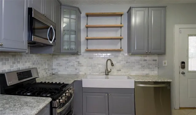 a kitchen with stainless steel appliances granite countertop a sink stove and microwave