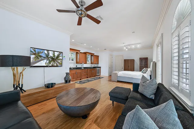 a living room with furniture kitchen view and a window