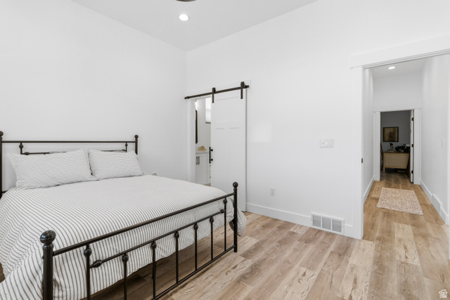 886 North 300th East Spring City, UT 84662 - Photo 18 of 40 Bedroom with light wood finished floors, connected bathroom, recessed lighting, and a barn door