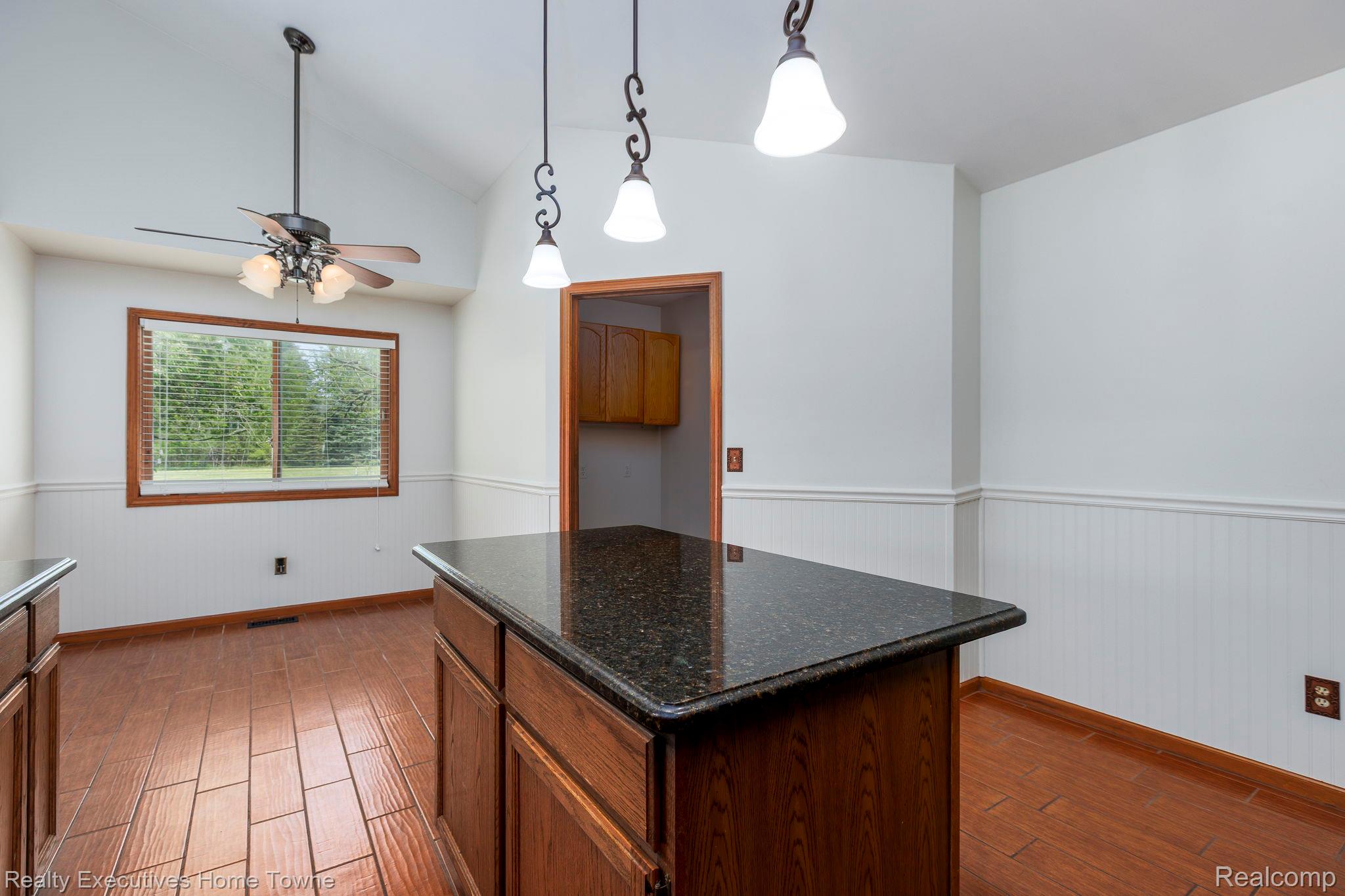 1041 Mackie Road Almont, MI 48003 - Photo 30 of 56 Kitchen featuring a wainscoted wall, hanging light fixtures, dark wood finished floors, a kitchen island, and vaulted ceiling