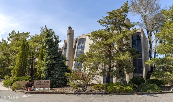 a front view of a house with a yard and tree s