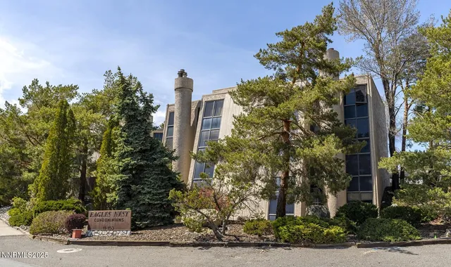 a front view of a house with a yard and tree s