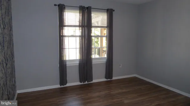 an empty room with wooden floor and closet