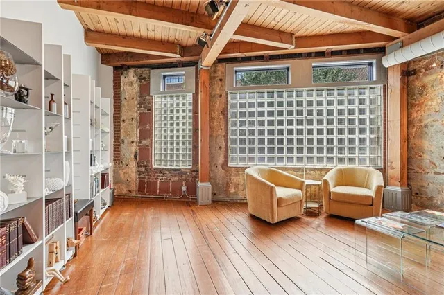 a dining room with wooden floor a chandelier a glass table and chairs