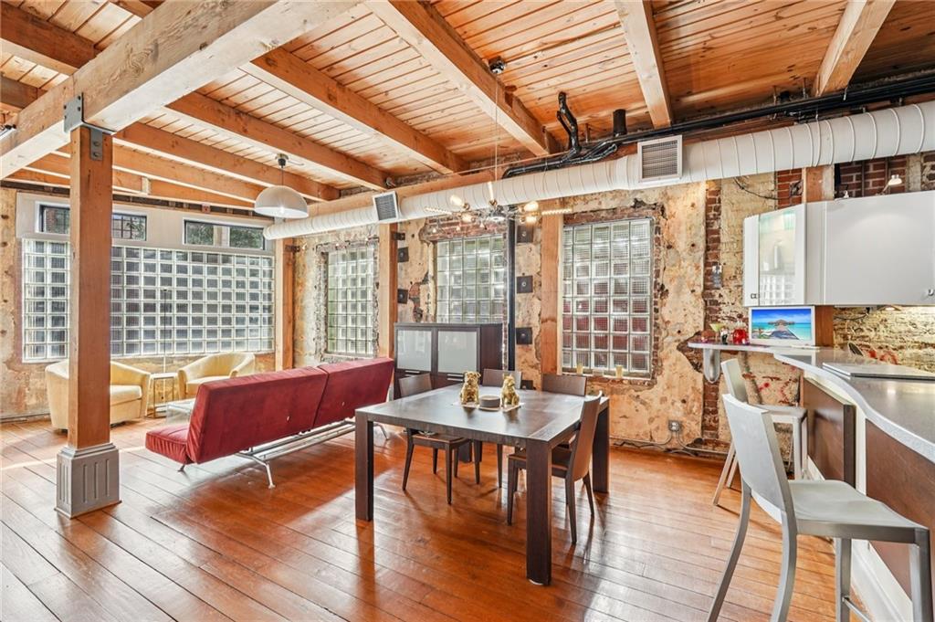 205 Walker Street Southwest, Unit G8 Atlanta, GA 30313 - Photo 14 of 41 a dining room with wooden floor a chandelier a glass table and chairs