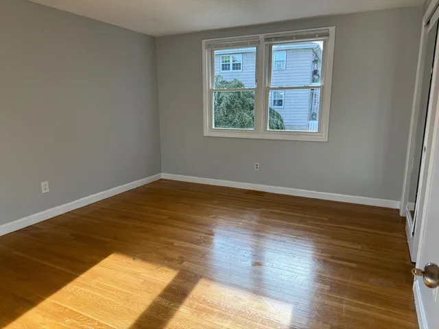 a view of a room with wooden floor and windows