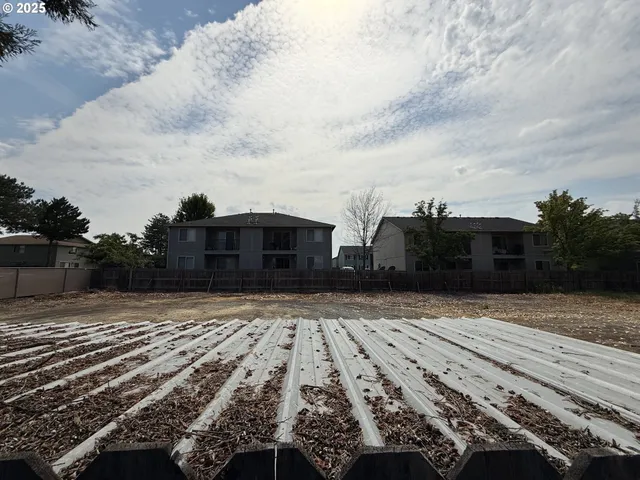 a view of a yard with cars on road